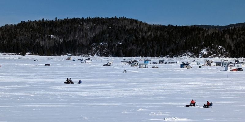 Village de pêche blanche sur les glaces du fjord du Saguenay à La Baie, hébergement à proximité pour pêcheurs et familles — Auberge des 21